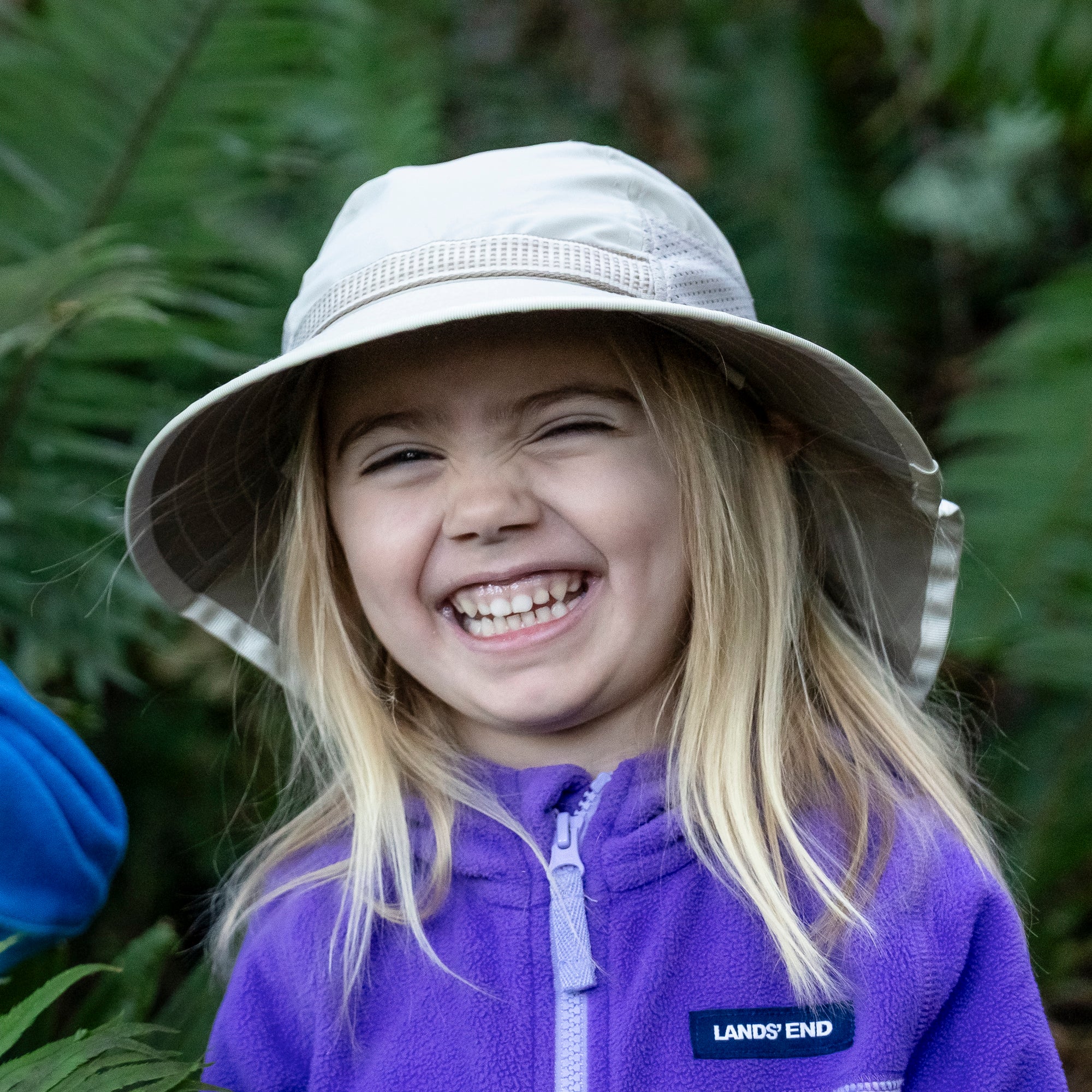 A girl wearing a Sunday Afternoons Kids' Play Hat in the Cream Chameleons color.