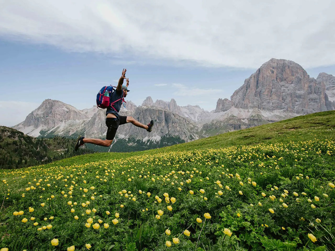 man jumping with his arms up in a field of dandelions
