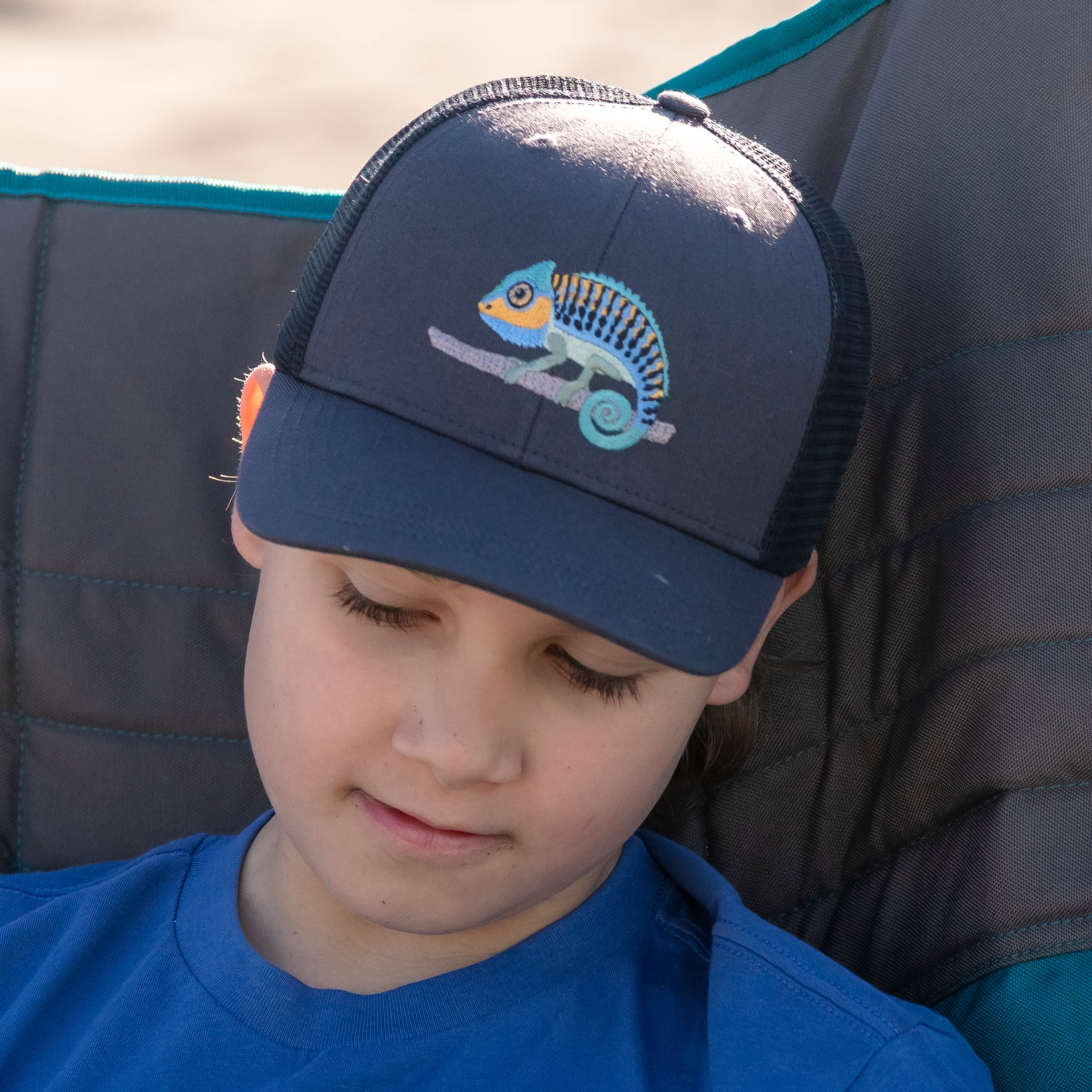 Child wearing a Sunday Afternoons Kids' Feel Good Trucker in the Clingin' Chameleons color.