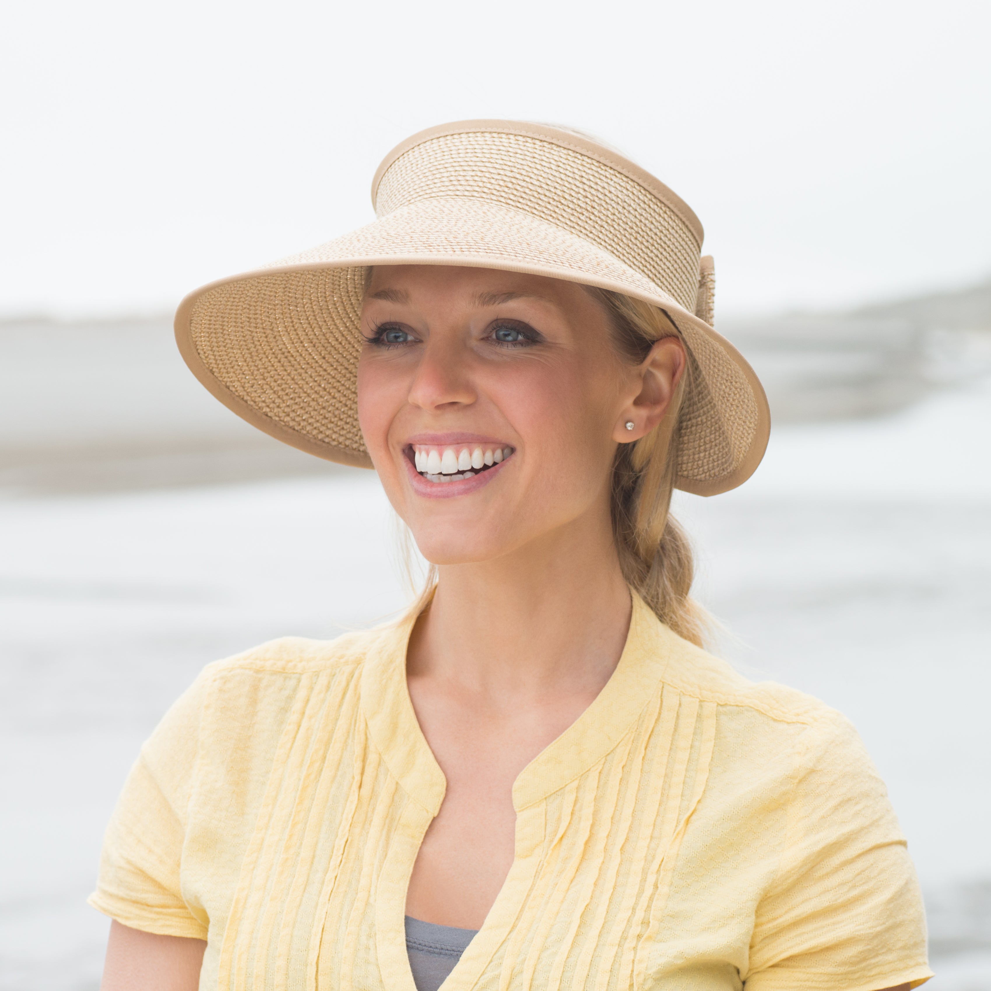 Woman on beach with sun visor